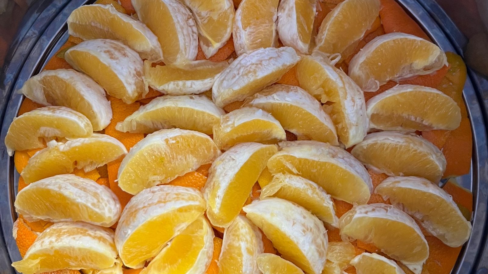 Fresh orange slices arranged in a stainless still — house-made citrus hydrosol at Awaken Zen Spa