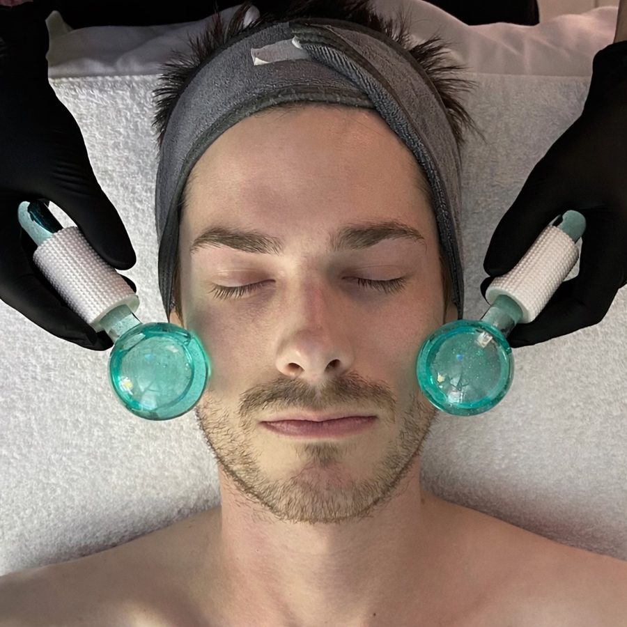 Thermal Vitality Glow facial treatment with dual ice globes applied to male client's face at Awaken Zen Spa in Mesa, AZ